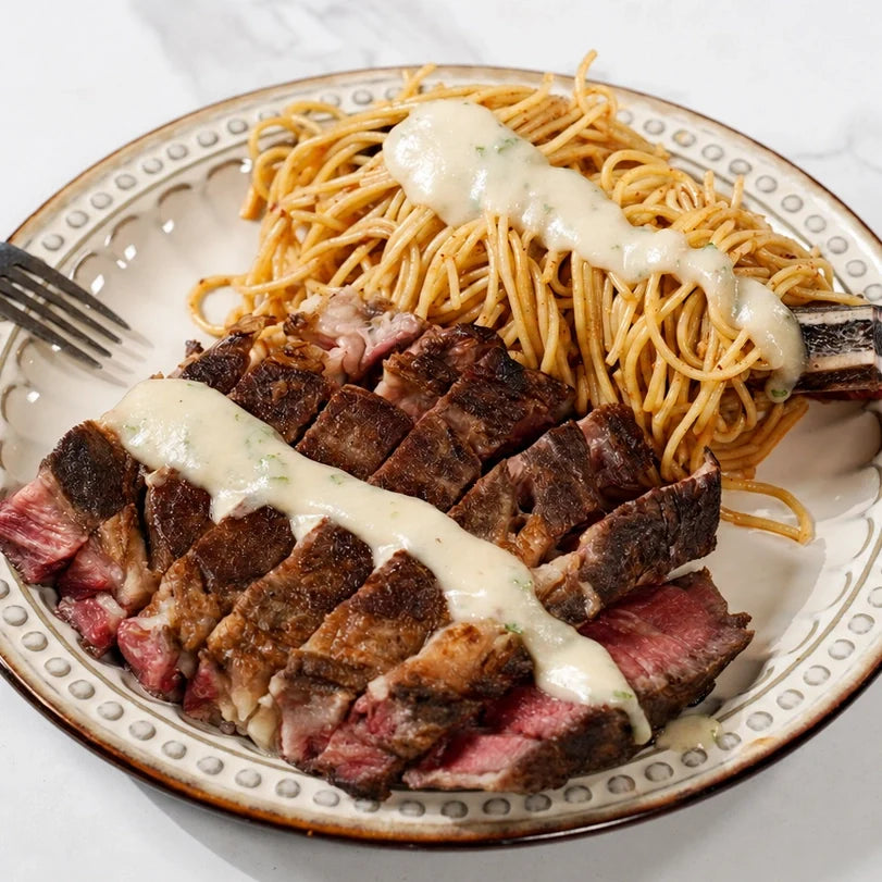 Steak Tomahawk confit à l’ail avec pâtes épicées