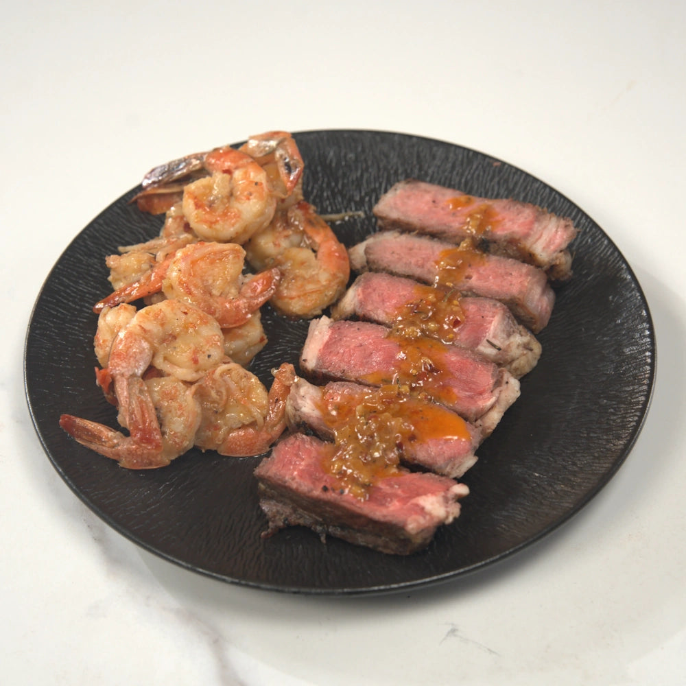 Bistec a la parrilla con camarones a la mantequilla de ajo